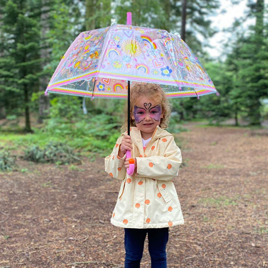 Child using fairy ballerina umbrella outdoors showing full dome coverage with rainbow and ballerina pattern