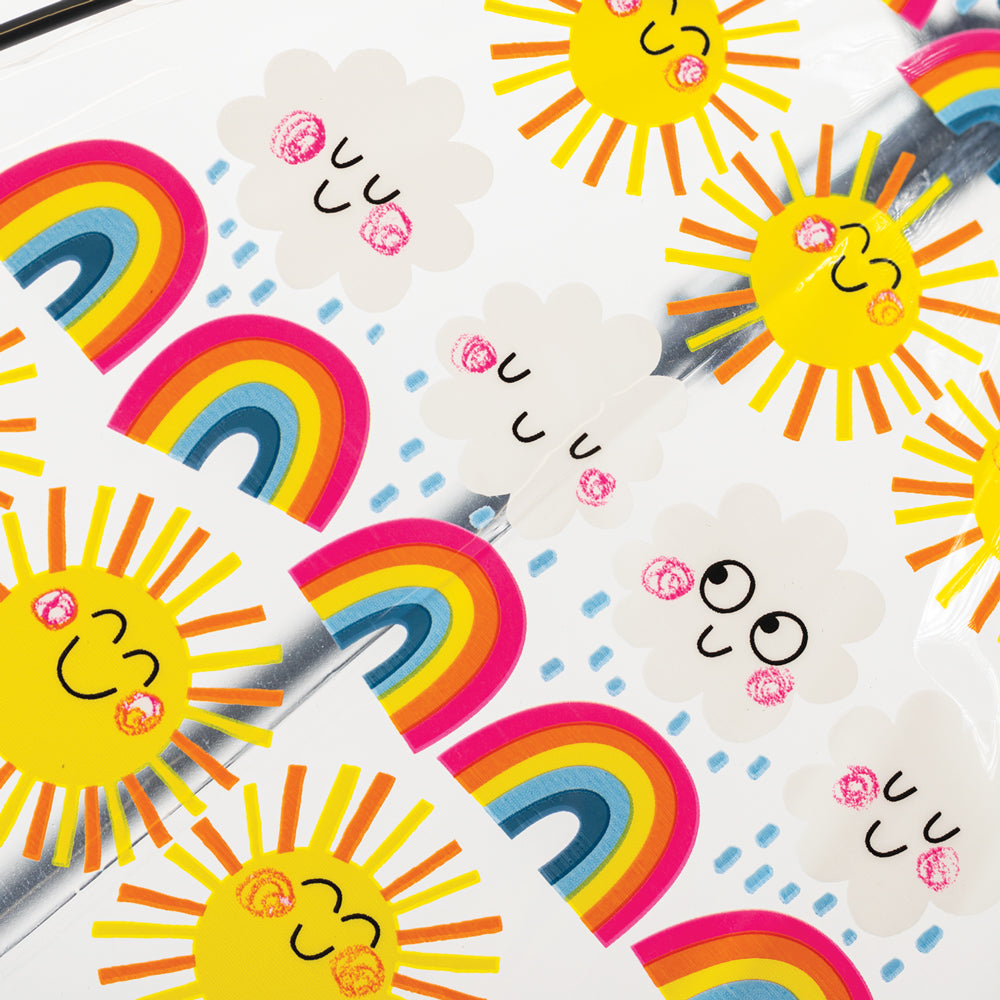 Close-up detail of sun rainbows and clouds umbrella showing smiling yellow suns and rainbow stripes