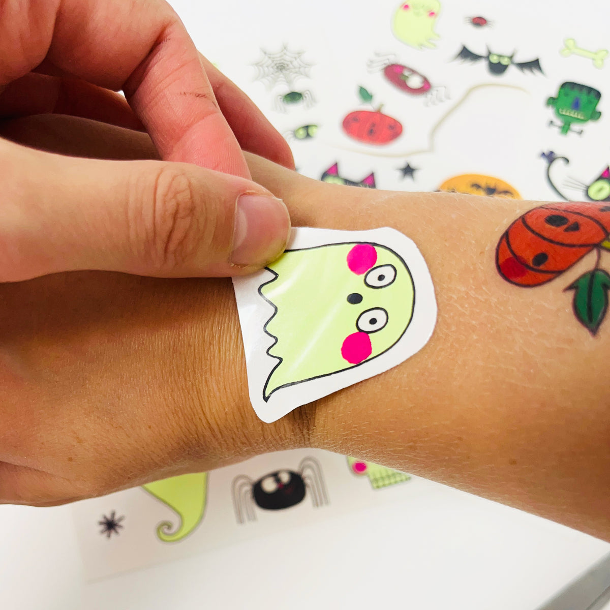 Applying spooky Halloween glow in the dark temporary tattoos