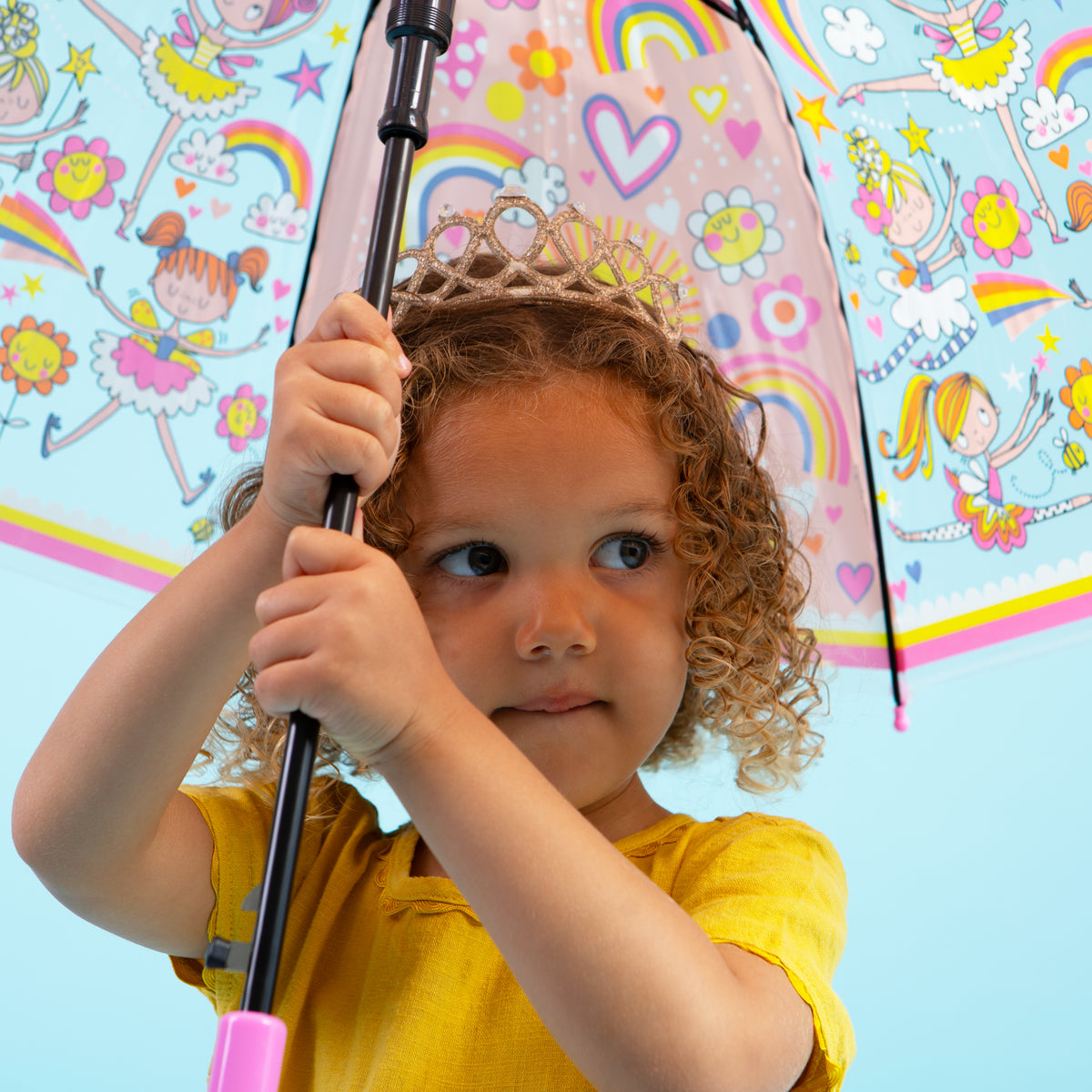 Girl holding fairy ballerina umbrella displaying clear dome with pink ballerinas and rainbow design
