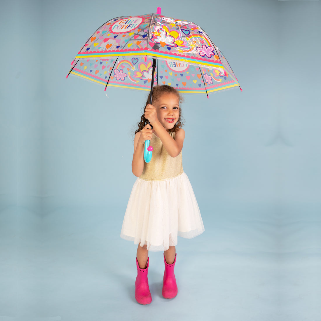Child wearing pink wellies holding girl power umbrella showing full dome coverage